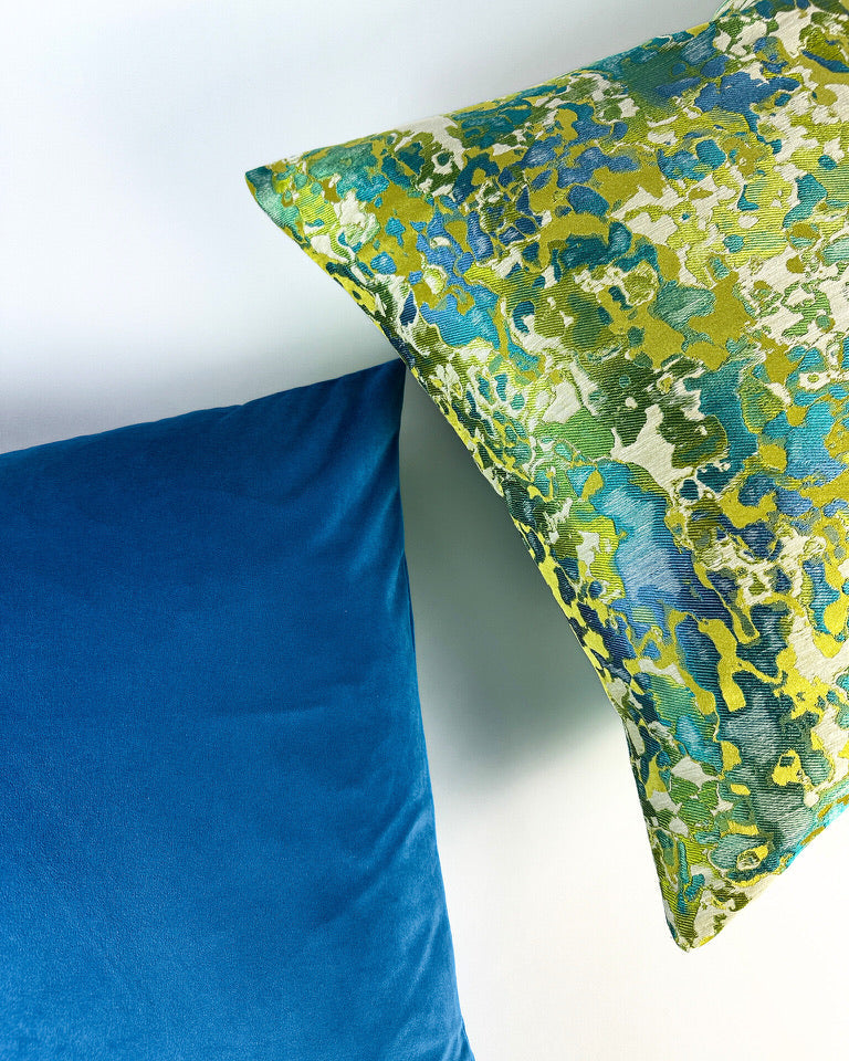 Abstract pattern pillow cover with aqua and teal color scheme on white backdrop