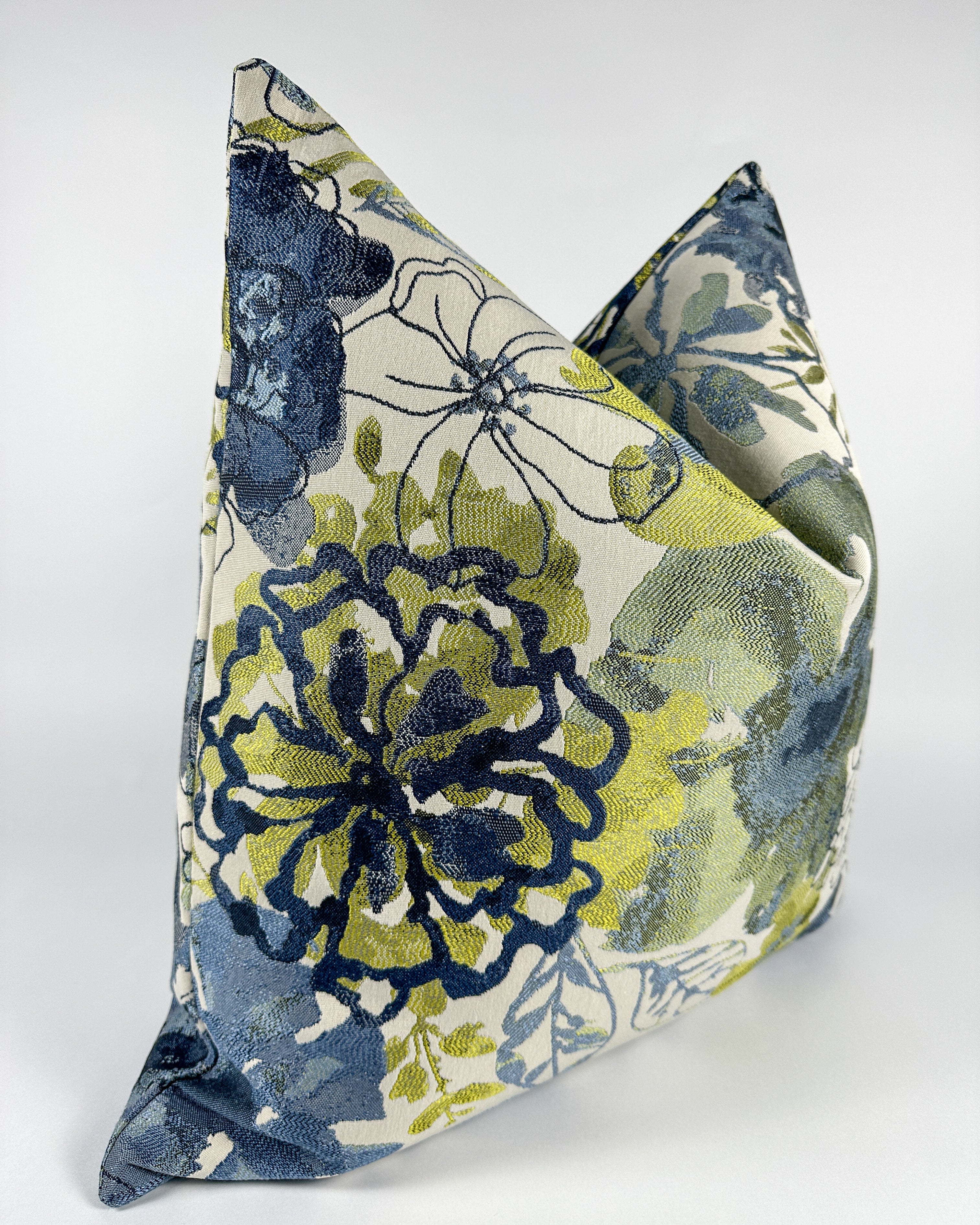 A triangular-shaped pillow cover with a floral pattern in blue and green shades.