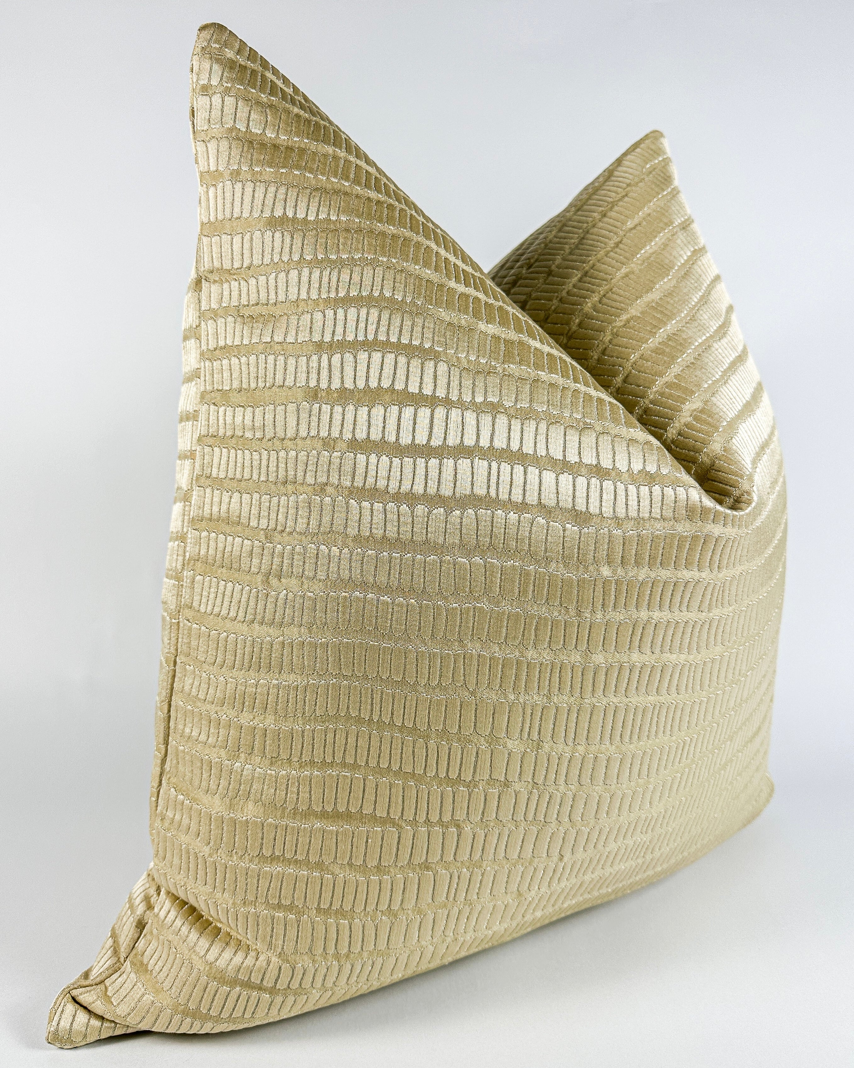 A champagne gold pillow cover with a textured design, that reveals the shimmering silver undertone.