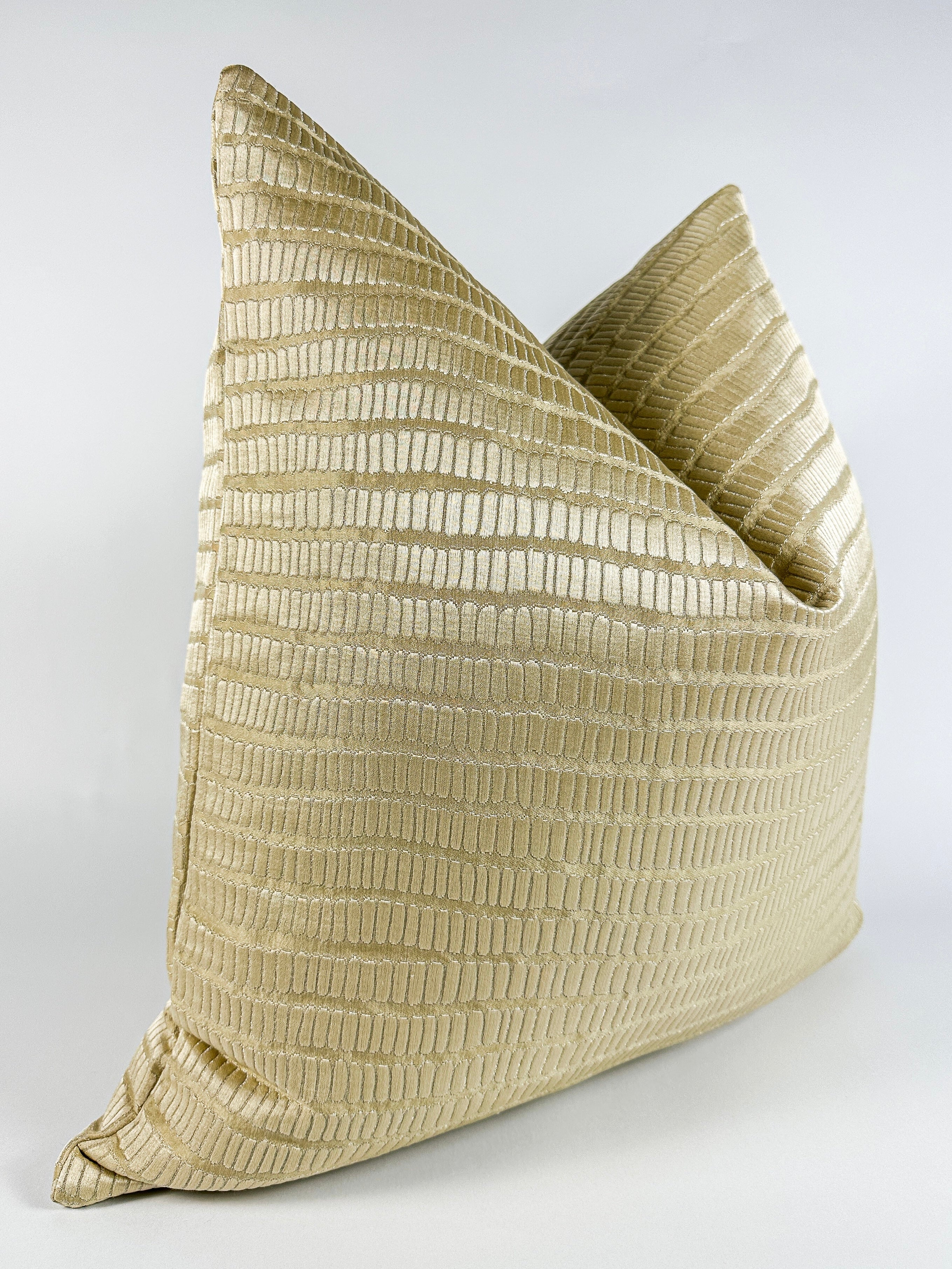 A champagne gold pillow cover with a textured design, that reveals the shimmering silver undertone.