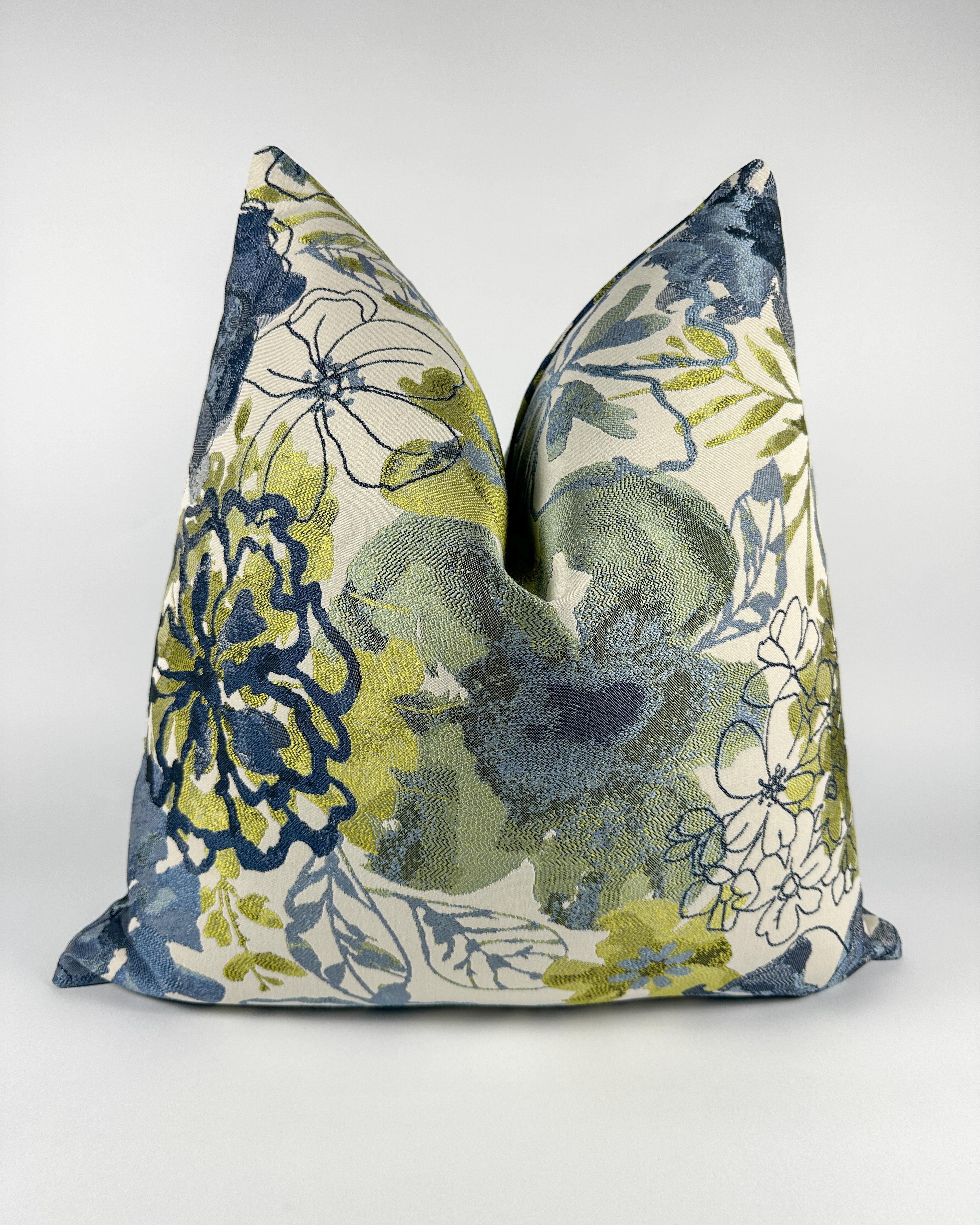 A triangular-shaped pillow cover with a floral pattern in blue and green shades.